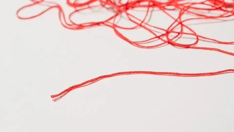 Red thread tangled on a white background, close-up view of fibers Stock Photos