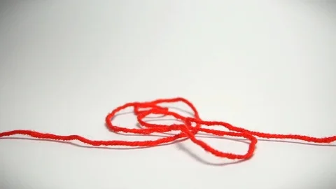 Red thread wriggles on a white background Stock Footage 99575685