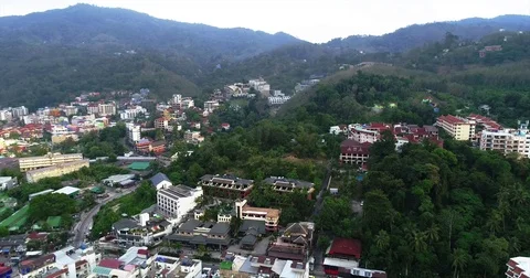 Red tile rooftops climbing the green slopes above town 库存影片 71297879