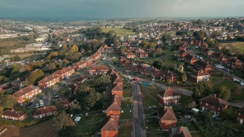 Red-tiled homes stretch in neat rows, framed by green fields Vidéo 343561802
