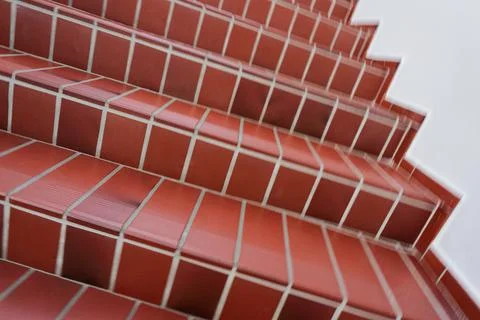 Red tiled staircase with rounded white concrete walls Stock Photos
