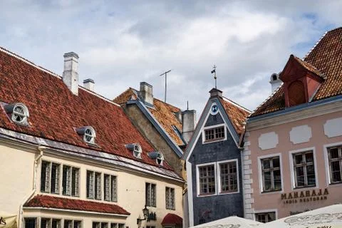Red tiled triangular roofs of an old European city with wooden windows, with old Stock Photos