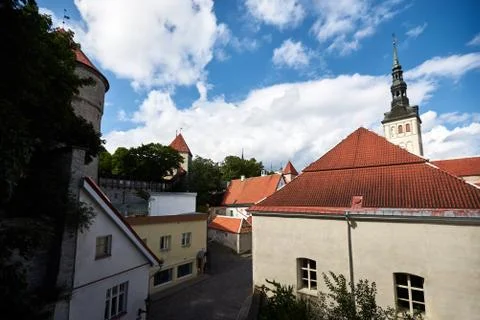 Red tiled triangular roofs of an old European city with stone pavements and road Stock Photos