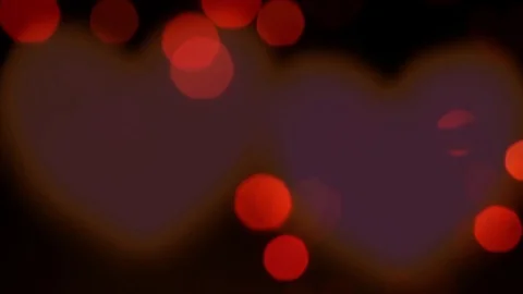 Red tilting lights and red harts shape turning softly in 360 degrees ina blac Stock Footage 128524195