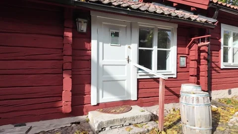 Red Timber House Facade with White Door and Wooden Barrels in Sweden Video stock 347682808