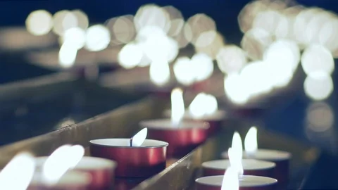 Red tiny candles waving in a dark background in a church. Soft focus. Stock Footage 101899081