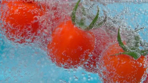 Red tomato close-up under water. Juicy vegetable with a bubble on blue Stock Footage 171308626