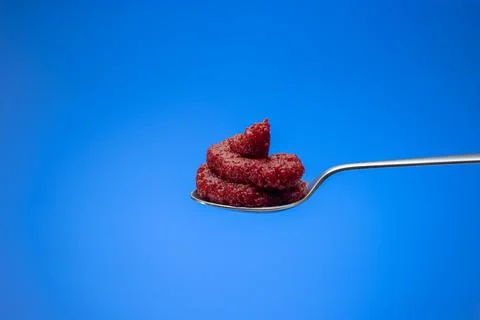 Red tomato concentrate paste in a small spoon. Close up studio shot, isolated Fotos de archivo