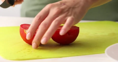 Red Tomato is cut into small pieces on a cutting board. Close-up. Stock Footage 250177888
