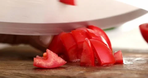 Red Tomato is cut into small pieces on a cutting board. Close-up. Stock Footage 250482332
