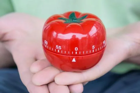 Red tomato kitchen timer set to 0, held by both hands, with open palms Stock Photos