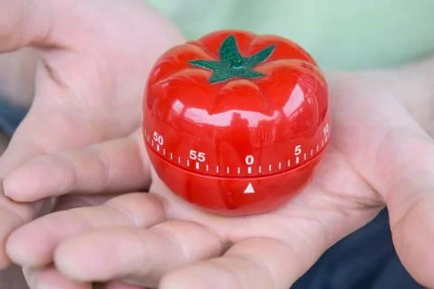 Red tomato kitchen timer set to 0, held by both hands, with open palms Stock Photos