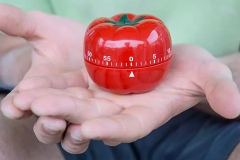 Red tomato kitchen timer set to 0, held by both hands, with open palms Stock Photos