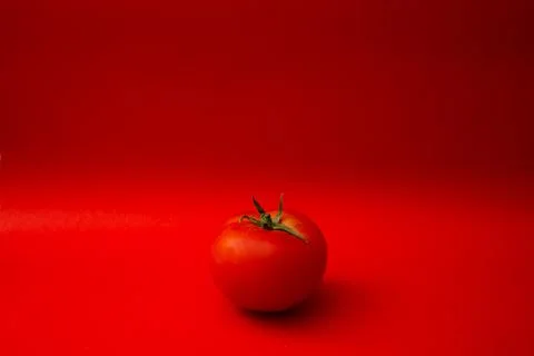 Red tomato on a red background Foto stock