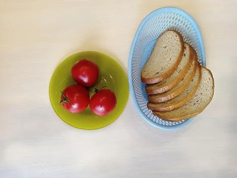 Red tomatoes and rustic bread on the table 写真素材