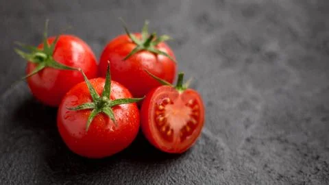 Red tomatoes on a black background Stock Photos