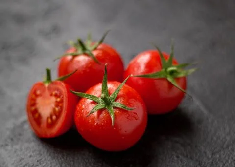 Red tomatoes on a black background Stock Photos