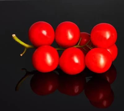 Red tomatoes on black background Stock Photos