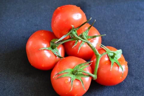 Red tomatoes on a black table Stock Photos