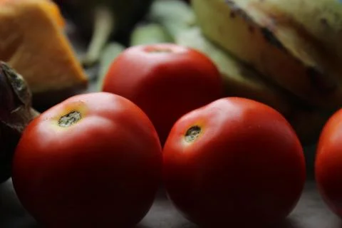 Red tomatoes display with multiple vegetables for health and diet background. Stock Photos