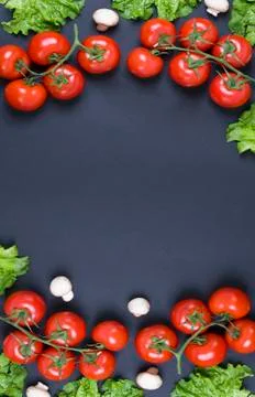 Red tomatoes with lemons on a black background. Stock-Fotos