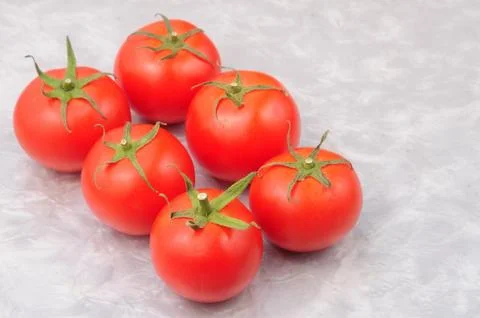 Red tomatoes on a marble background Stock Photos