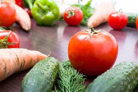 Red tomatoes on a table on a background of vegetables. Fresh tomatoes on a wo Stock-Fotos
