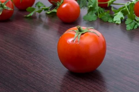 Red tomatoes  on a table on the background of vegetables. Stock Photos