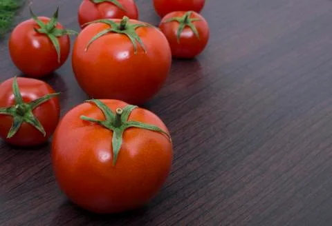 Red tomatoes  on a table on the background of vegetables. Stock Photos