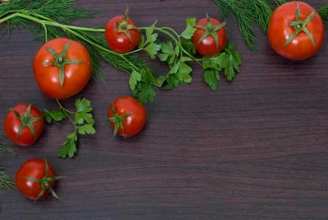 Red tomatoes  on a table on the background of vegetables. Stock Photos