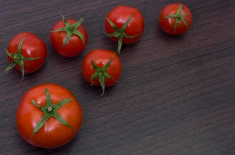 Red tomatoes  on a table on the background of vegetables. Stock Photos