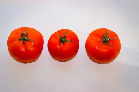 Red tomatoes on a white surface Stock Photos