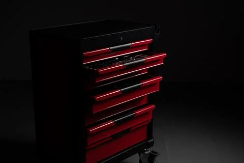 Red tool chest with multiple open drawers in dark workshop Stock Photos