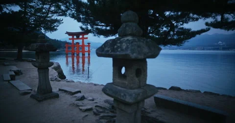 Red Torii Gate Standing in Water at Dusk with Stone Lanterns Stock Footage 344700315