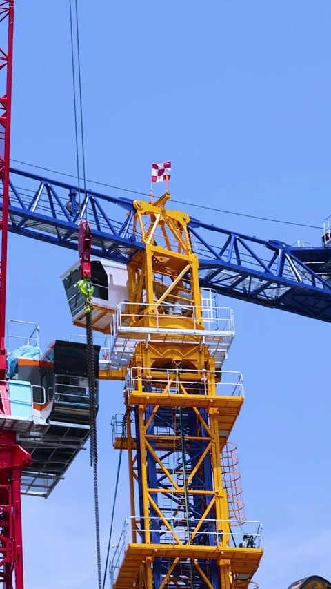 Red Tower Crane Lifting Section Onto Yellow Crane Structure Stock Footage 314306644
