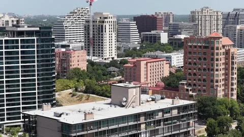 A red tower crane rising over mid-rise construction in Dallas aerial drone view Stock Footage 342492567