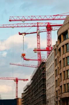 Red tower cranes on construction site Stock Photos