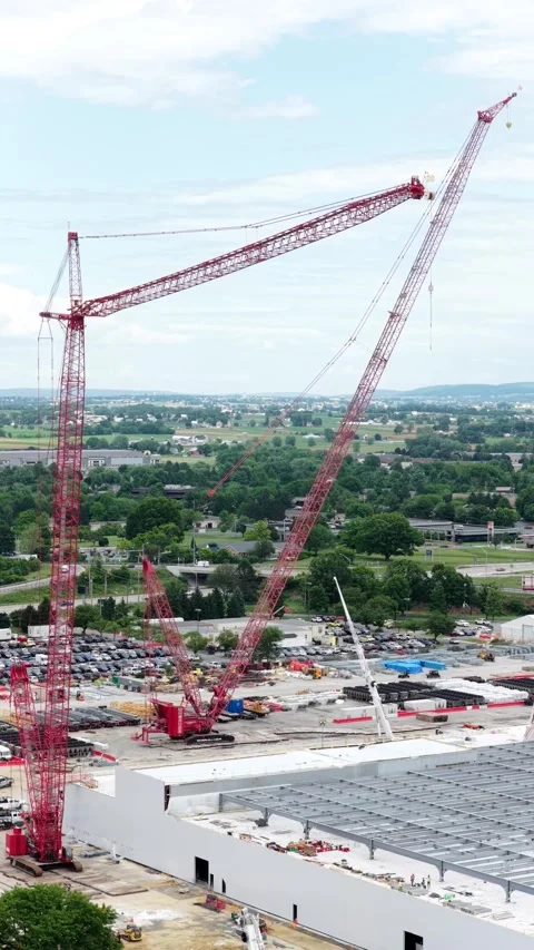 Red tower cranes rise above data center construction site near Lancaster Stock Footage 340992351