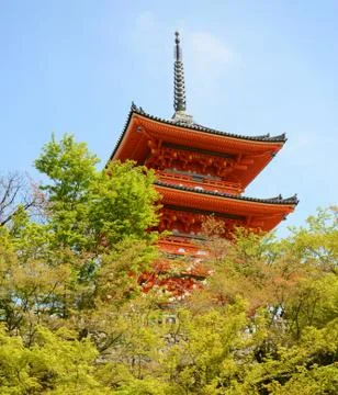 Red Tower of Temple behind the trees in sunny day Foto stock