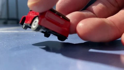 Red toy car model with renewable solar panel electricity driving blue tile sunny Video stock 232976871