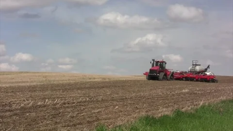 Red track tractor w Spring disc &amp; nitrogen trailers approach &amp; past Stock Footage 270238108