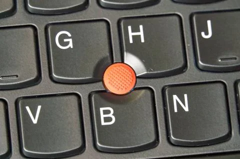 Red trackpoint - pointing stick on a laptop keyboard Stock Photos