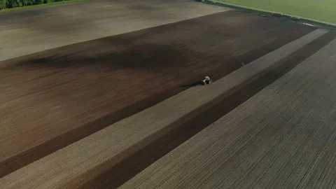 Red tractor with dual wheels doing the processing brown soil with a disc Stock Footage 115158702