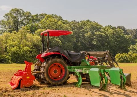 Red tractor at edge of field. Stock Photos