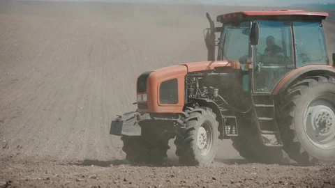 Red tractor with harrows prepares the dry field agricultural land. Stock Footage 128365237