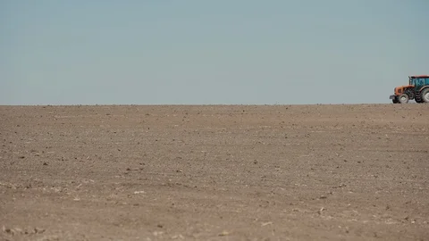 Red tractor with harrows prepares the dry field agricultural land. Stock Footage 128365425