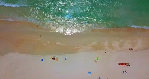 Red Tractor machine cleaning a tropical sand beach around tourists Stock Footage 88682551