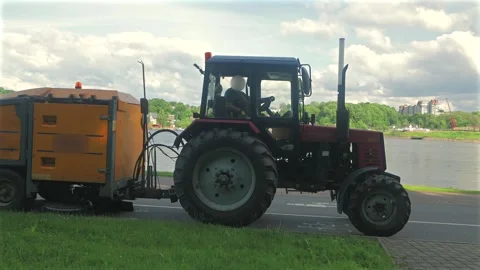 Red Tractor with Orange Street Sweeper Driving Along  Road Stock Footage 337880115