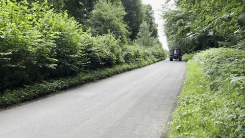 Red tractor passing by on a narrow road in Kent Video stock 204869696