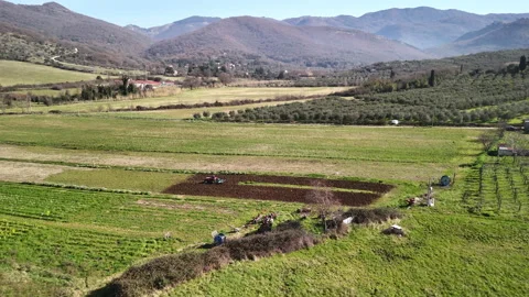 Red tractor plowing dry soil preparing it for sowing, aerial view shot of Stock-Footage 317118691